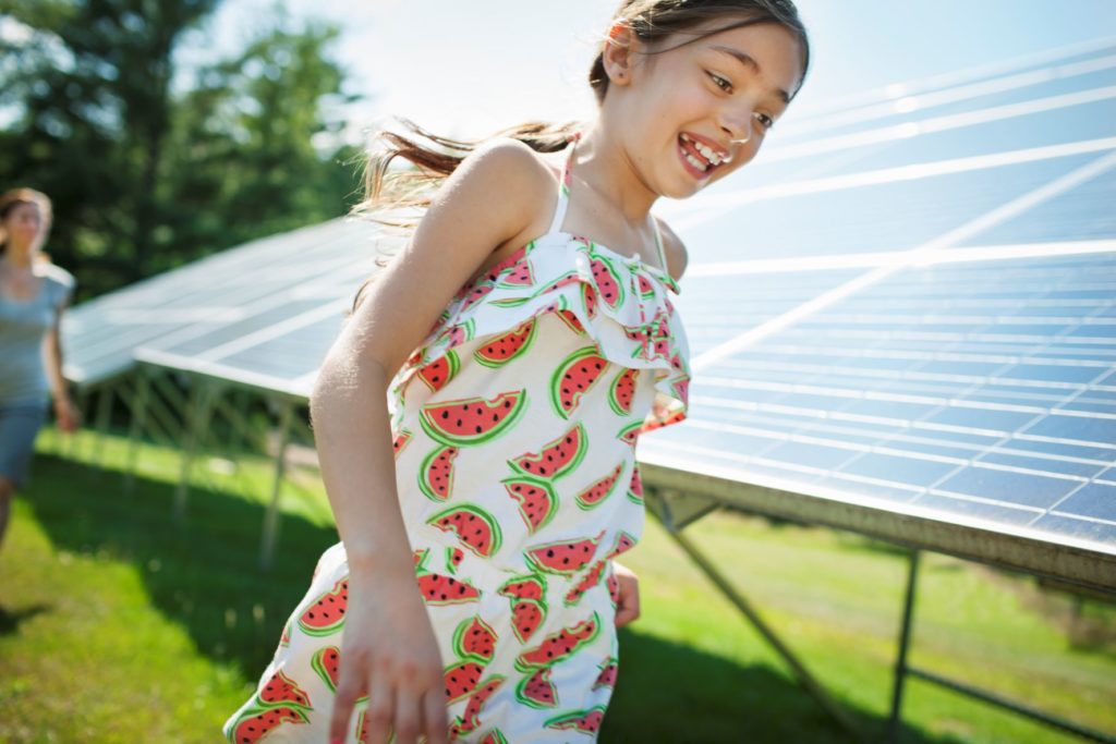 A child and mother beside solar panels in Roseville.